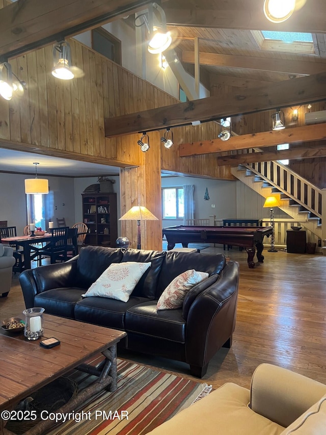 living room with high vaulted ceiling, hardwood / wood-style flooring, wood walls, and beam ceiling