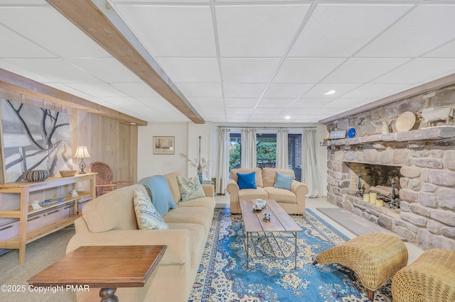 carpeted living room with a drop ceiling and a fireplace