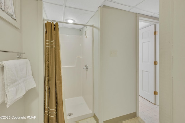 bathroom with a drop ceiling and walk in shower