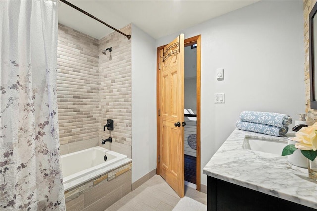 full bath with vanity, tiled shower / bath, and baseboards