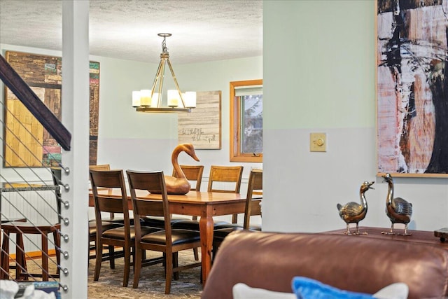 dining space with a chandelier and a textured ceiling