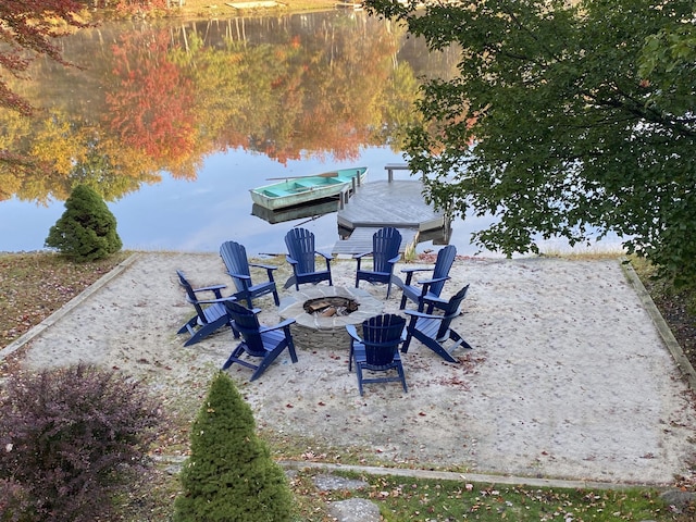 view of yard with a fire pit, a floating dock, and a water view