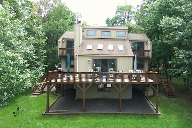 back of property featuring stairway, roof with shingles, a chimney, a balcony, and a yard