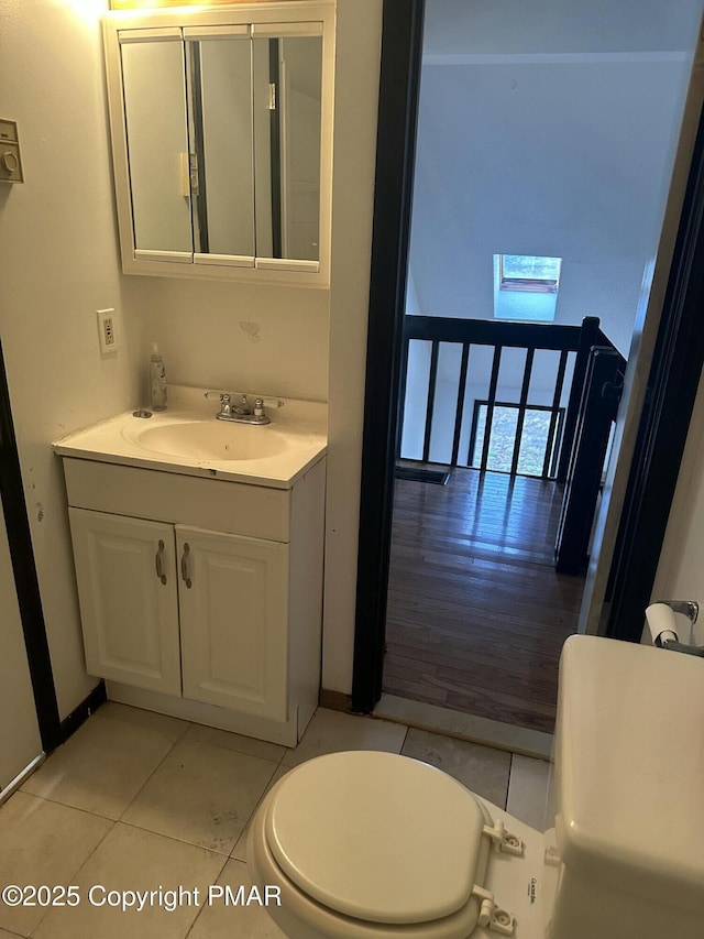 half bath featuring vanity, toilet, and tile patterned floors