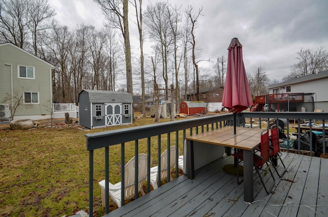 deck featuring a yard, an outdoor structure, and a storage unit