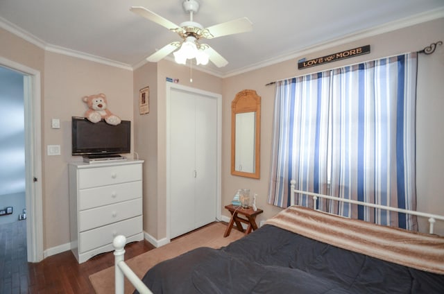 bedroom featuring crown molding, a closet, a ceiling fan, wood finished floors, and baseboards