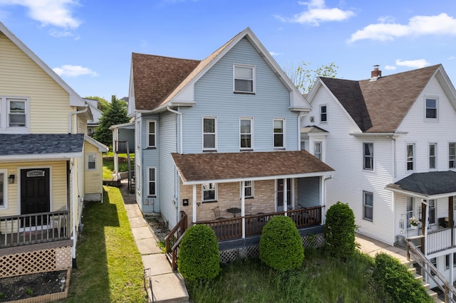 view of front of home featuring covered porch and a shingled roof