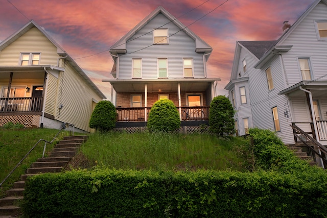 view of front of property featuring covered porch and stairway
