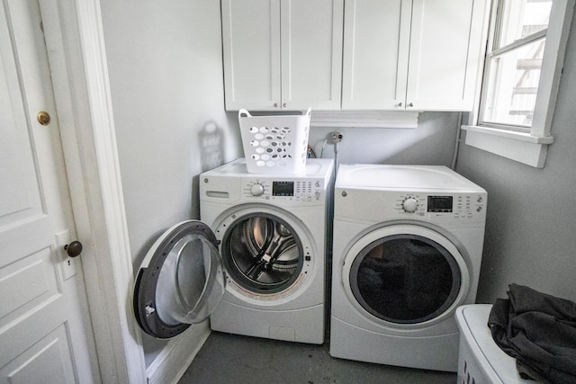 washroom featuring washing machine and dryer and cabinet space