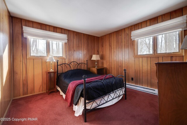 bedroom with dark colored carpet, a baseboard radiator, and wooden walls