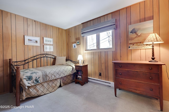 bedroom featuring light colored carpet, wooden walls, and a baseboard heating unit