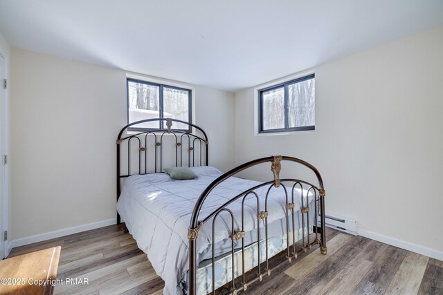 bedroom featuring hardwood / wood-style floors and baseboard heating