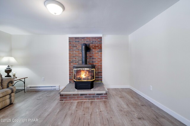 living room with a baseboard radiator, wood-type flooring, and a wood stove