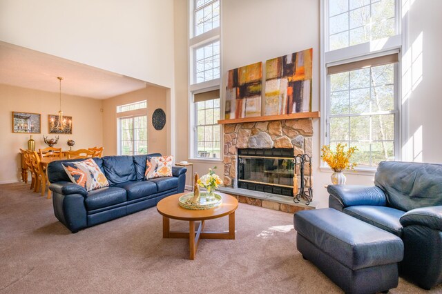 355 Windy Bush Rd, Pocono Pines, PA 18350 - living room with carpet floors, a towering ceiling, a chandelier, healthy amount of natural light, and a fireplace