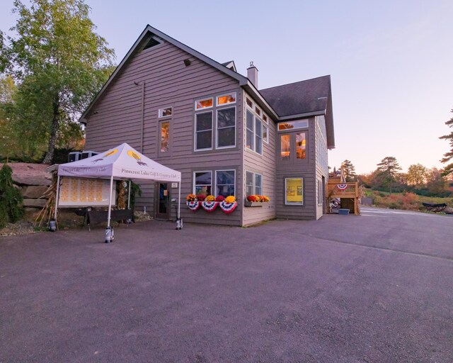 355 Windy Bush Rd, Pocono Pines, PA 18350 - back of property at dusk featuring a chimney