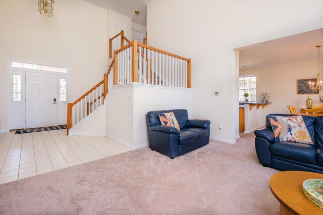 355 Windy Bush Rd, Pocono Pines, PA 18350 - carpeted living area featuring a chandelier, a high ceiling, stairs, baseboards, and tile patterned floors