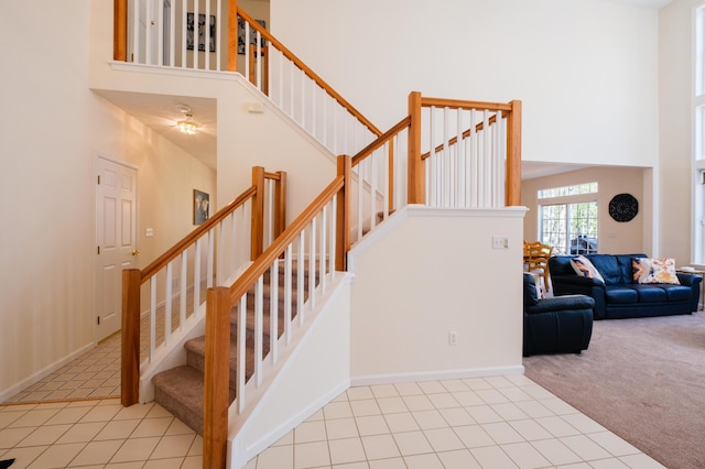 355 Windy Bush Rd, Pocono Pines, PA 18350 - staircase featuring a towering ceiling, carpet flooring, tile patterned floors, and baseboards