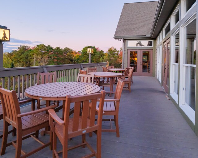 355 Windy Bush Rd, Pocono Pines, PA 18350 - patio terrace at dusk with french doors, outdoor dining area, and a wooden deck