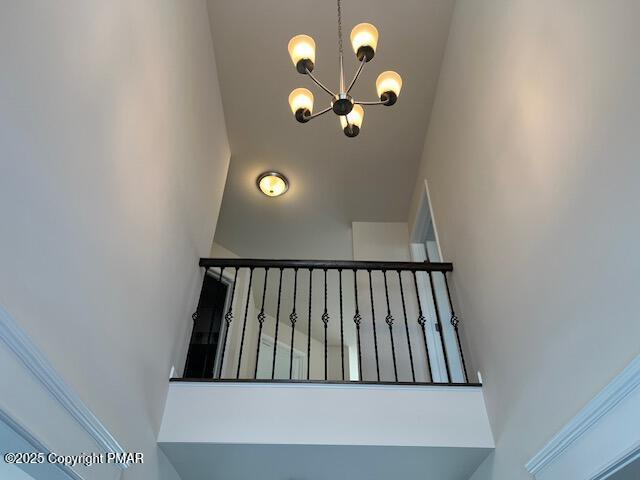 stairway featuring a notable chandelier