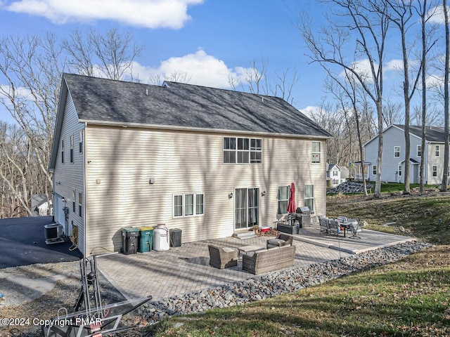 rear view of property with an outdoor living space, central AC unit, and a patio area