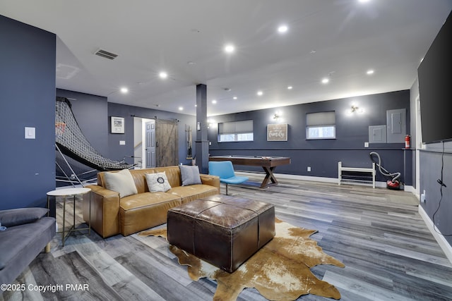 interior space with a barn door, visible vents, wood finished floors, and recessed lighting