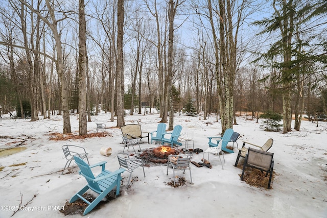 snowy yard with an outdoor fire pit