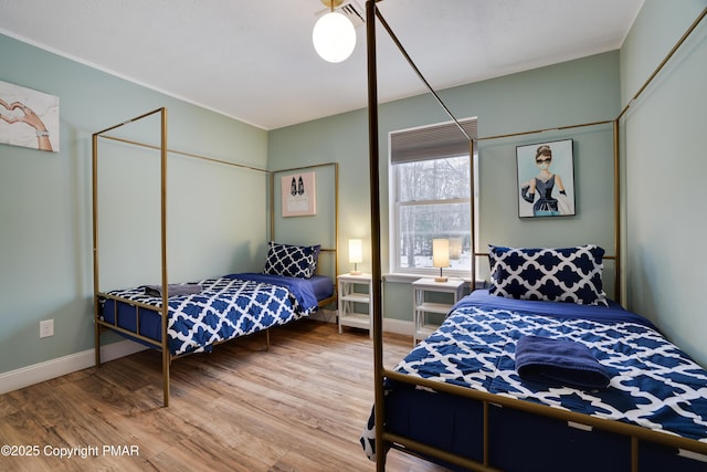 bedroom with baseboards and wood finished floors