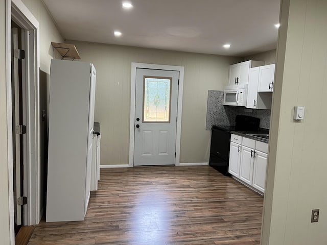 171 Linden Loop, Pocono Summit, PA 18346 - kitchen featuring white microwave, dark countertops, black range with electric stovetop, dark wood-type flooring, and white cabinetry