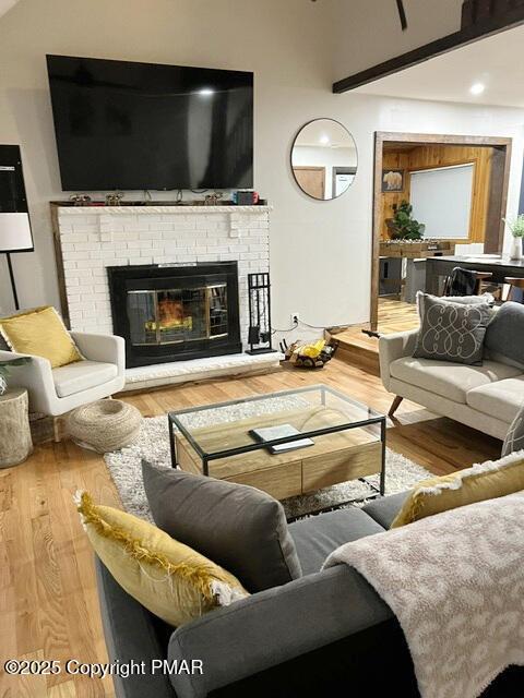 living room with a fireplace and wood finished floors