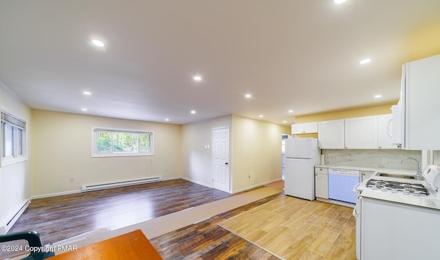 kitchen featuring white appliances, a baseboard radiator, light countertops, light wood-style floors, and a baseboard heating unit