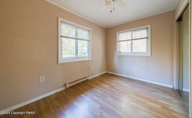 unfurnished room featuring ceiling fan, light wood-type flooring, ornamental molding, and a baseboard radiator