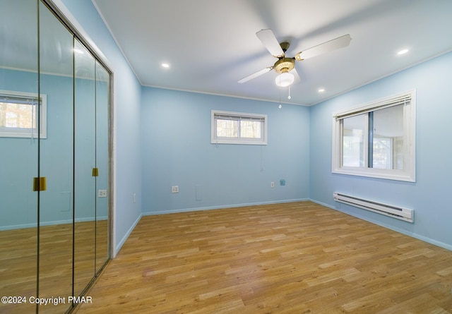 unfurnished bedroom featuring a baseboard radiator, recessed lighting, ornamental molding, a closet, and light wood-type flooring