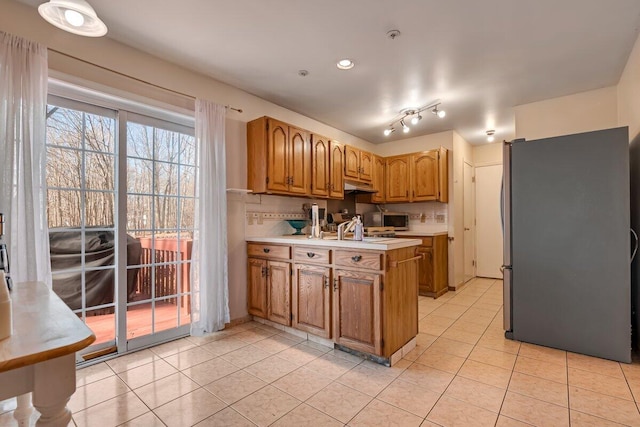 34 Heath Ln, Mount Pocono, PA 18344 - kitchen featuring stainless steel appliances, a peninsula, tasteful backsplash, light countertops, and light tile patterned floors