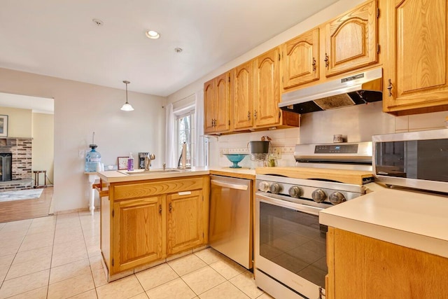 34 Heath Ln, Mount Pocono, PA 18344 - kitchen featuring appliances with stainless steel finishes, under cabinet range hood, a sink, a peninsula, and light countertops