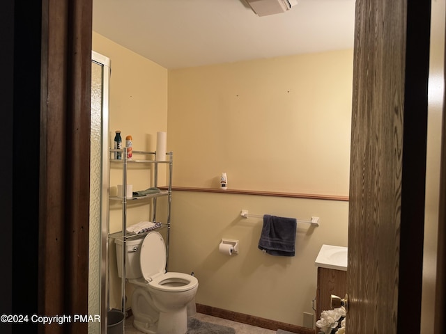 bathroom with baseboards, vanity, and toilet