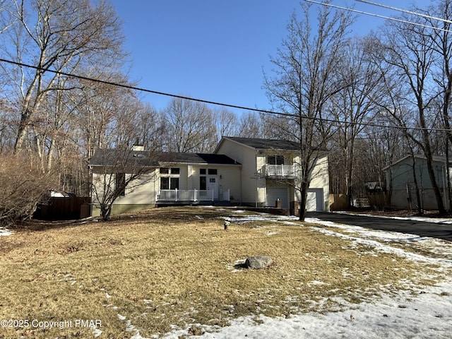 tri-level home featuring an attached garage, driveway, and a porch