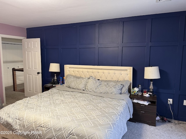 carpeted bedroom with visible vents and a decorative wall