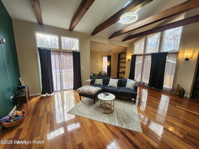 living area featuring vaulted ceiling with beams, wood-type flooring, and baseboards