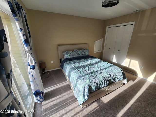 bedroom featuring carpet floors, a closet, visible vents, and baseboards