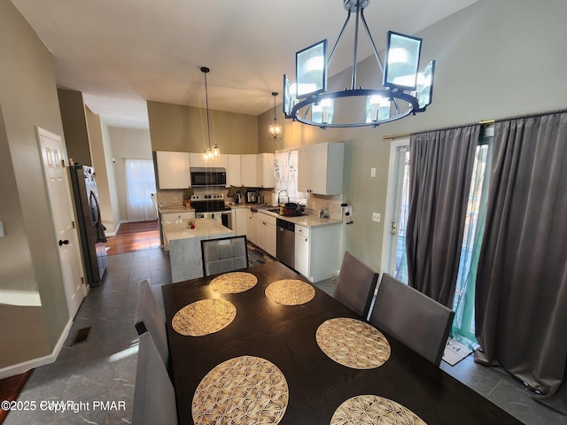 dining room featuring a towering ceiling, visible vents, and baseboards