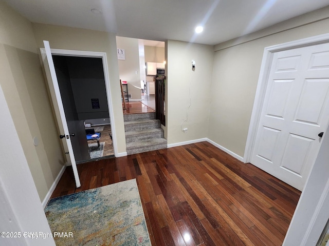 interior space featuring stairs, hardwood / wood-style flooring, and baseboards