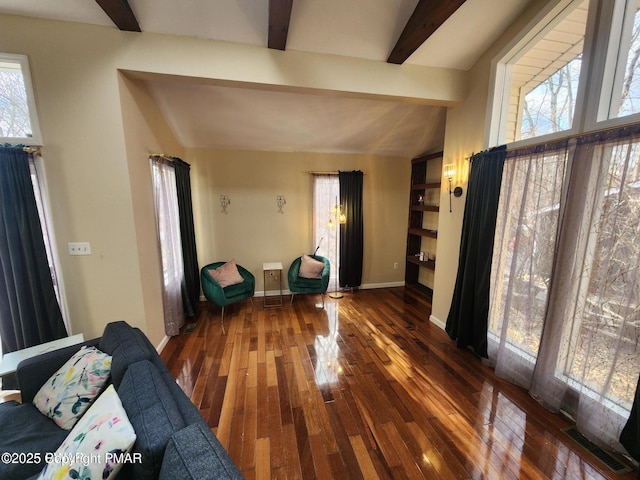 unfurnished living room with lofted ceiling with beams, wood-type flooring, visible vents, and baseboards