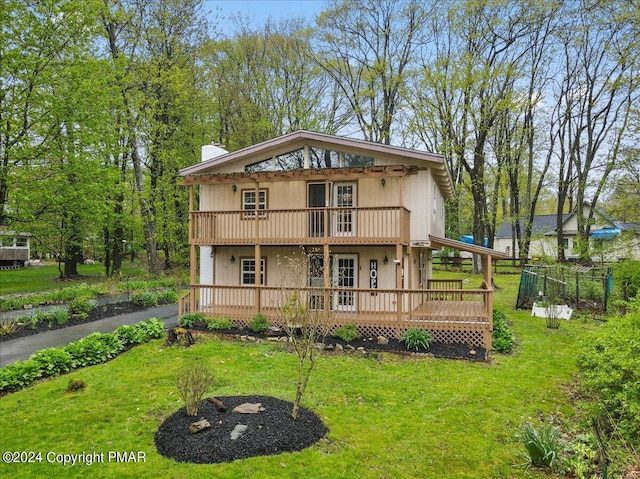 view of front of home featuring a chimney, a deck, and a front yard