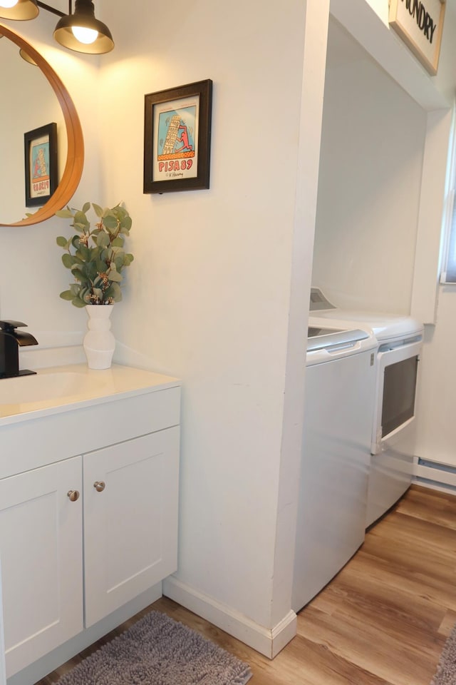5306 Ledgewood Dr, Tobyhanna, PA 18466 - laundry area featuring cabinet space, a sink, baseboards, light wood-type flooring, and washing machine and dryer