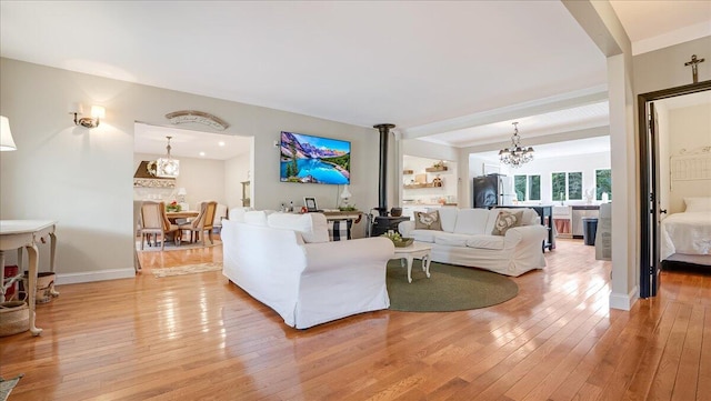 106 Silver Ln, Cresco, PA 18326 - living room featuring light wood-type flooring, a chandelier, a wood stove, and baseboards
