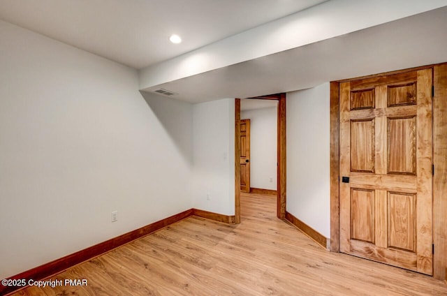 finished basement featuring recessed lighting, baseboards, visible vents, and light wood finished floors