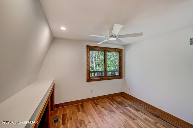 interior space featuring visible vents, ceiling fan, light wood-style flooring, and baseboards