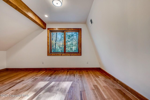 bonus room featuring visible vents, vaulted ceiling with beams, baseboards, and wood finished floors