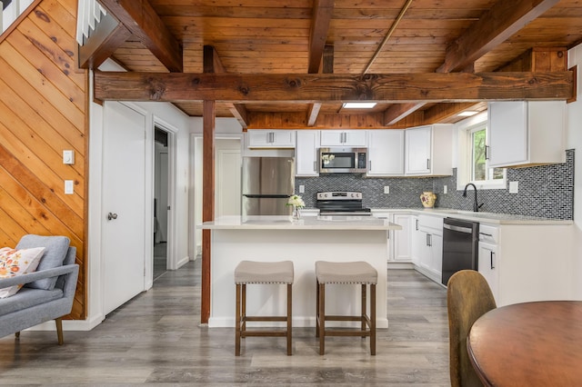 2162 Glasgow Dr, Bushkill, PA 18324 - kitchen with appliances with stainless steel finishes, a wooden ceiling with exposed beams, decorative backsplash, a center island, and white cabinetry