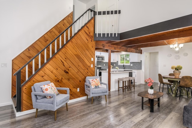 2162 Glasgow Dr, Bushkill, PA 18324 - living area featuring stairs, wood finished floors, a chandelier, beam ceiling, and wood walls